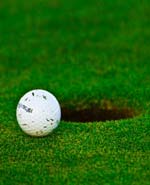 Une balle de golf au bord du trou